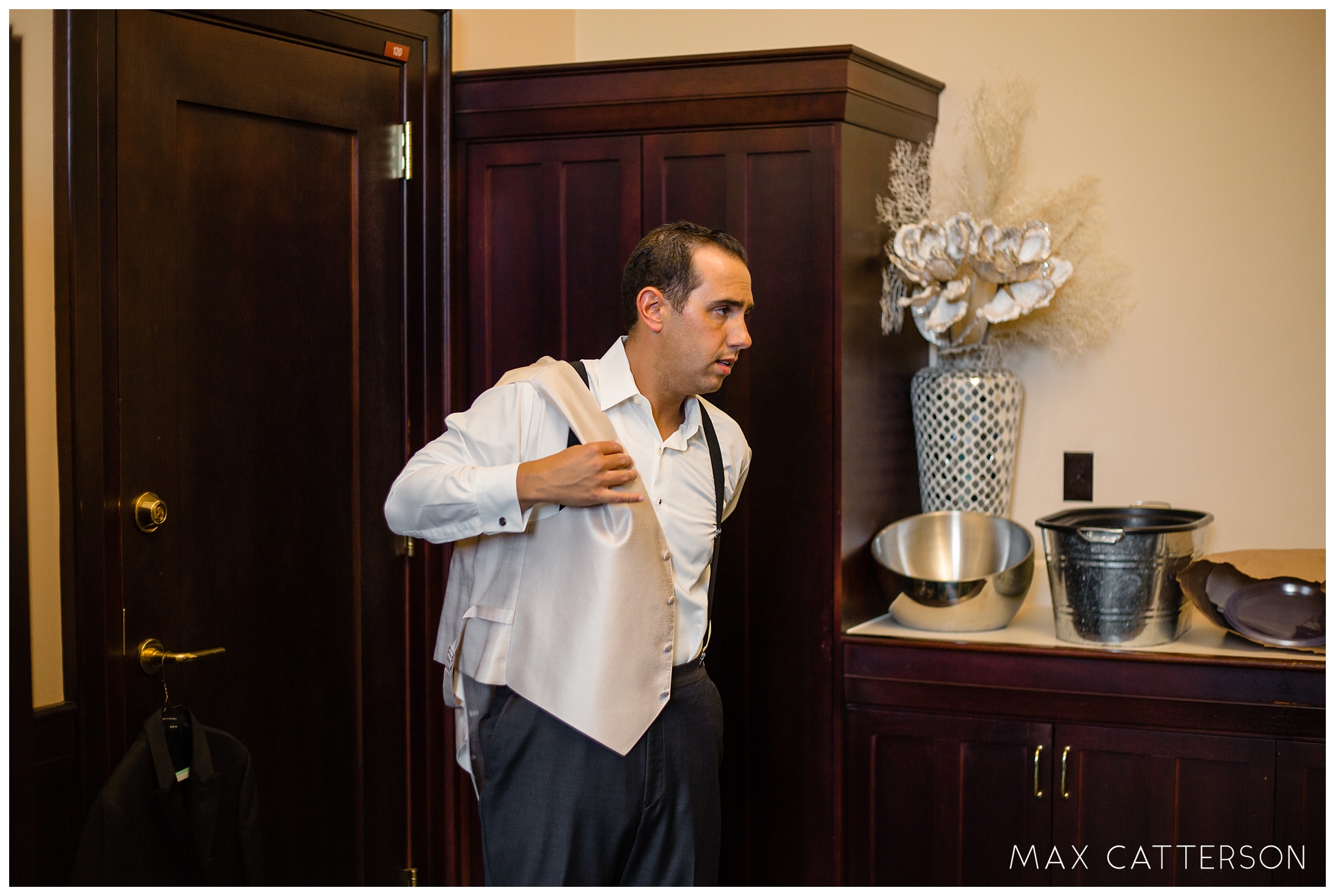 groom putting on vest