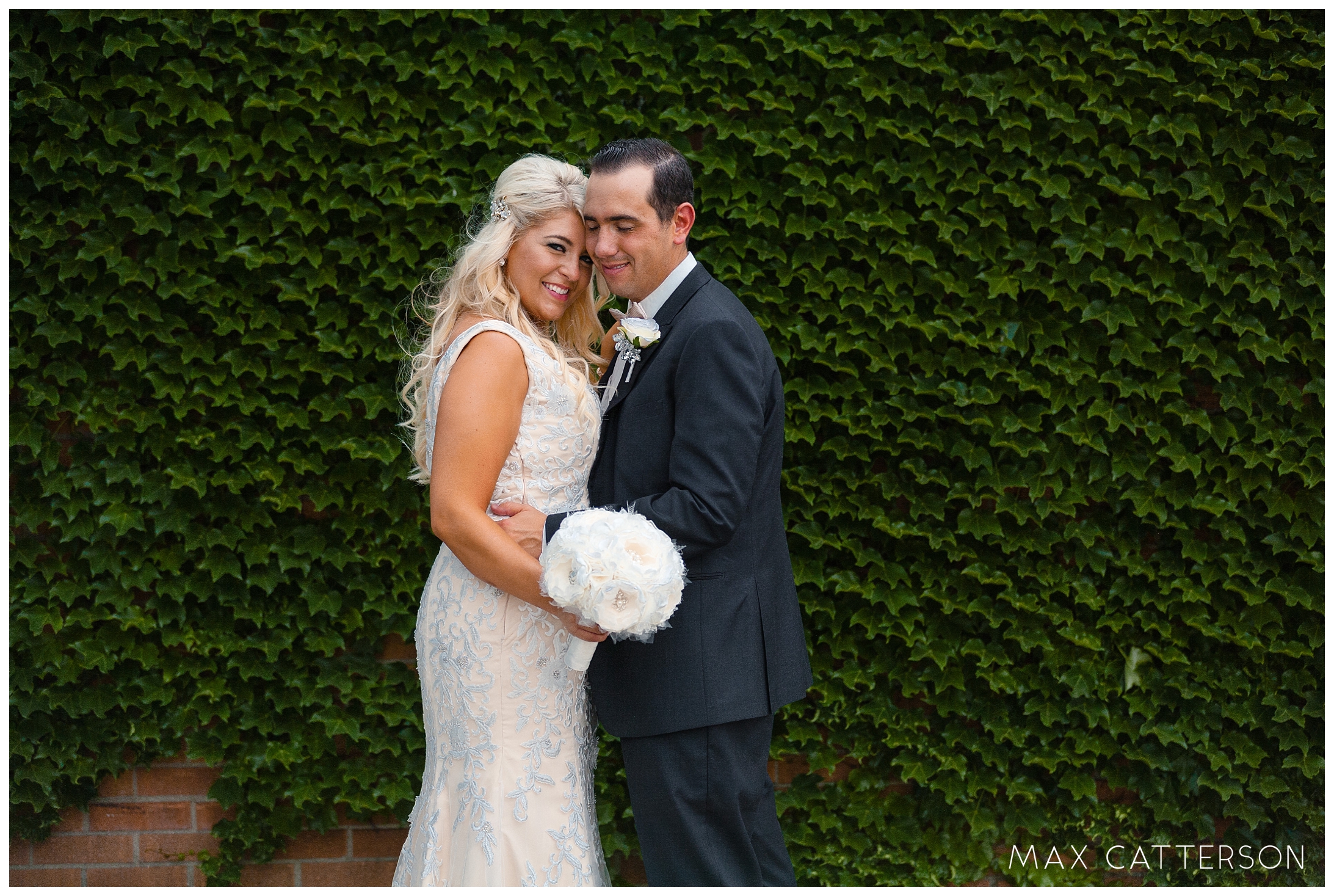 bride and groom in front of ivy